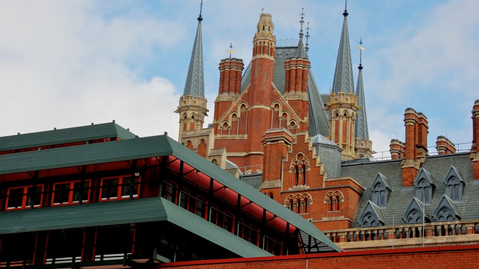 大英图书馆低矮的红砖建筑位于前景，St Pancras 的红砖塔楼从后方升起。