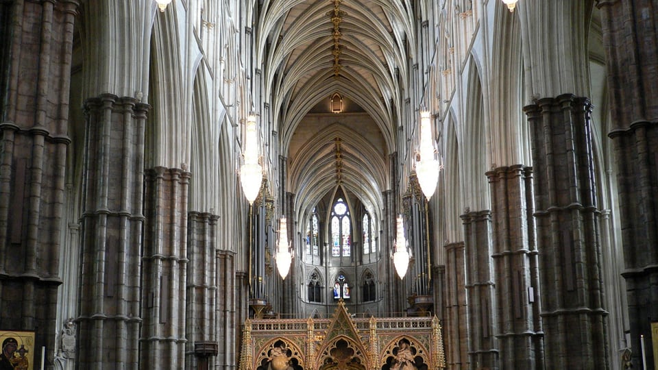 Westminster Abbey 中殿的高柱列与尖拱向远端延伸，上方肋架拱顶形成连续轴线。