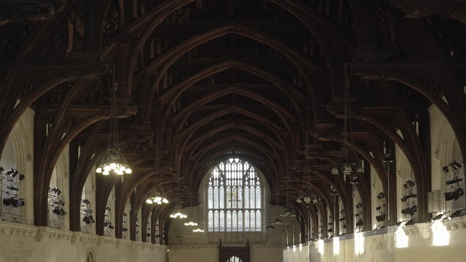 Westminster Hall 巨大的锤梁木屋顶沿大厅纵轴层层展开，石墙与高窗位于两侧。