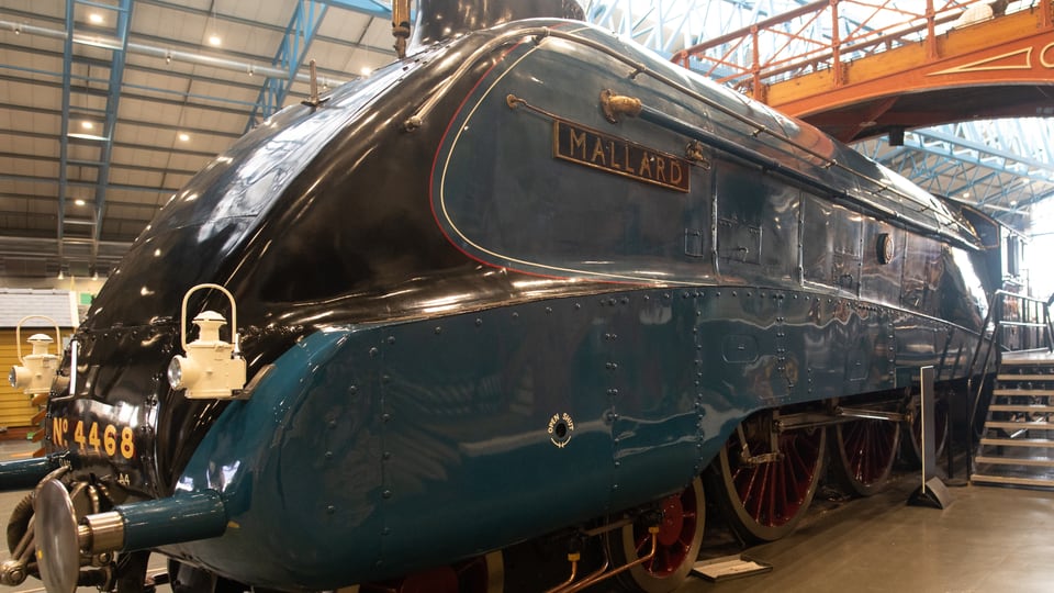 National Railway Museum 内 Mallard 蒸汽机车的流线型车头与深蓝车身从近处向后延伸。