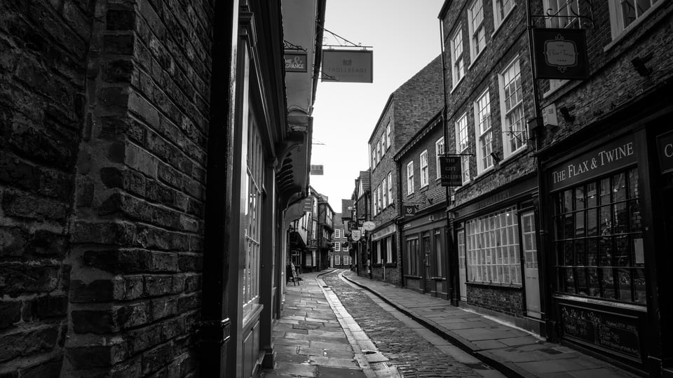 约克 Shambles 的石板路在窄街中弯向远处，两侧旧楼紧贴街面。
